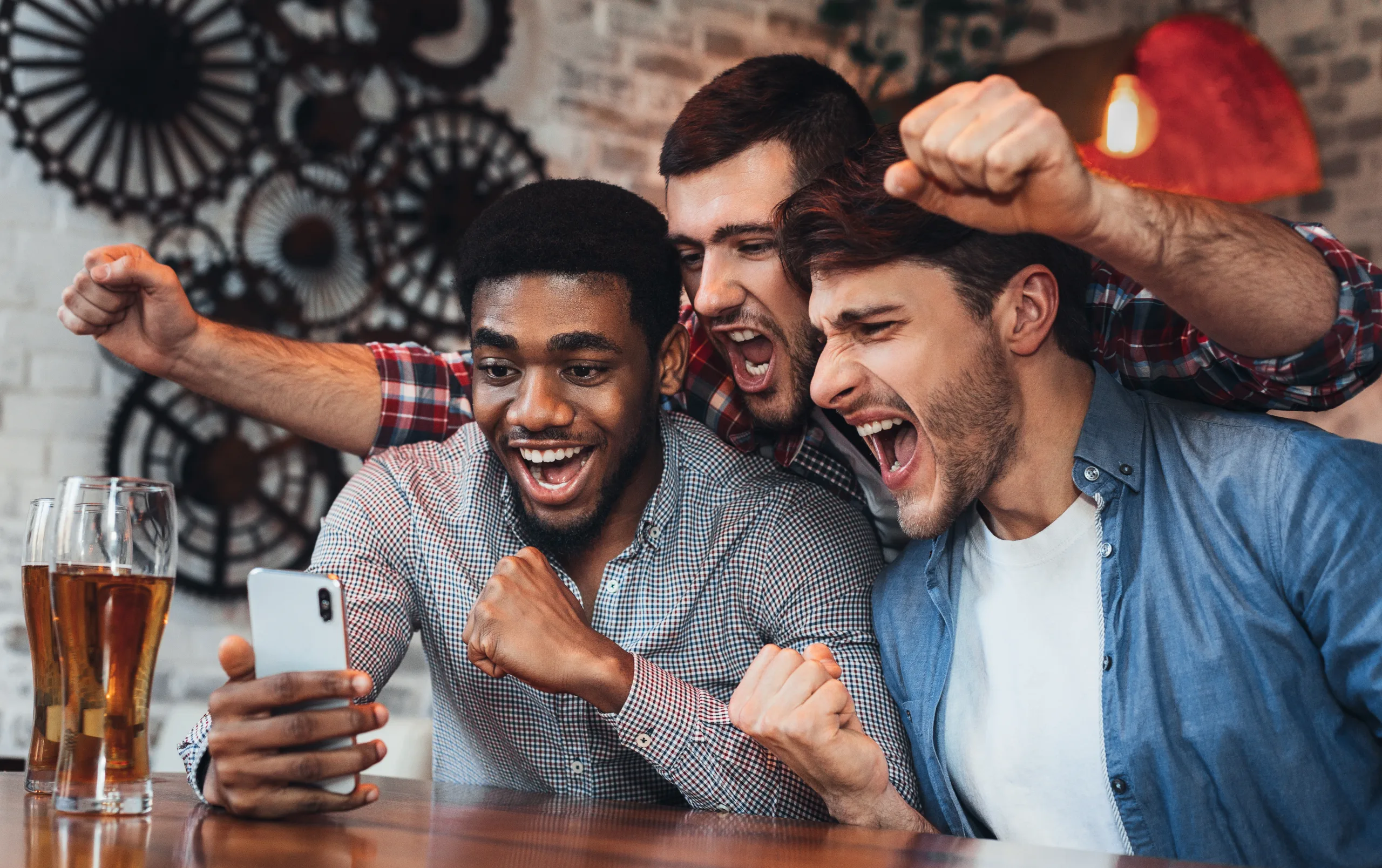 Men watching football on smartphone in bar