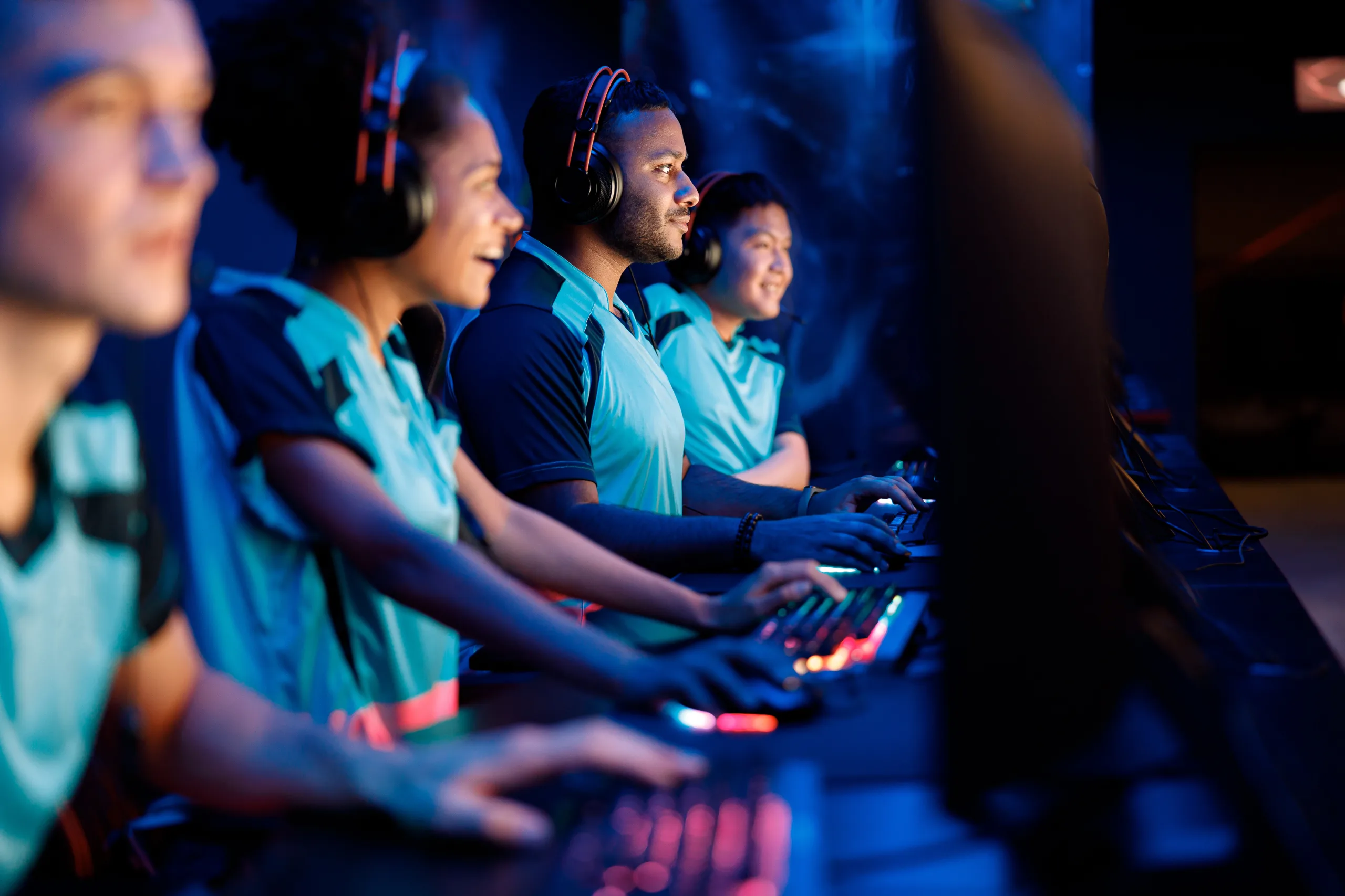 Team of professional gamers playing on pc in gaming club